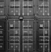Stacked black cargo containers with identification markings,shipping fashion items